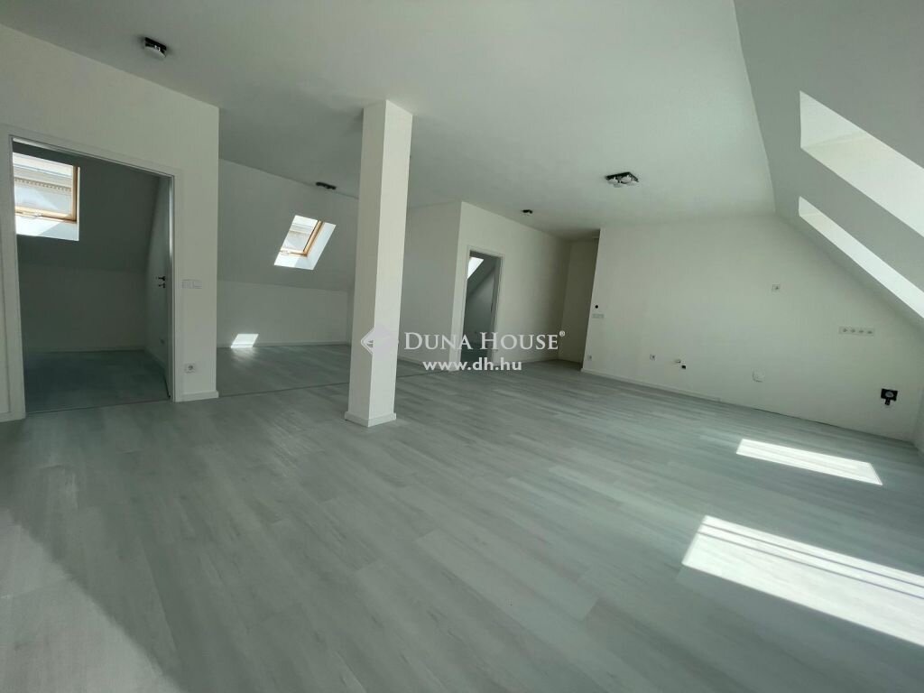 Modern tetőtéri nappali oszloppal és tetőablakokkal